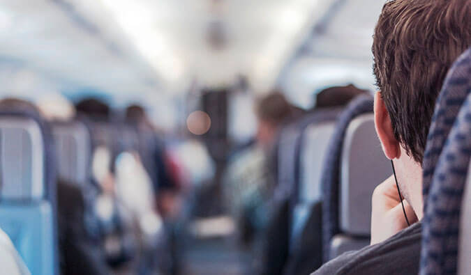 man with headphones in sat on an airplane