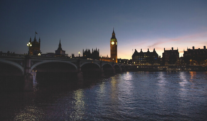 view over the river Thames at night looking towards big ben and The Houses of Parliament