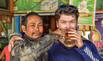 Will from The Broke Backpacker blog posing with a local in Asia