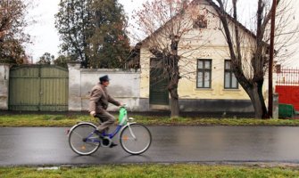 A man riding a bike through a quiet neighborhood