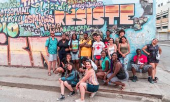 Students from FLYTE on a trip abroad posing near street art