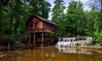An old wooden building beside a river in the American South