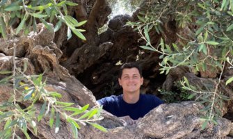 Nomadic Matt in an olive tree in Crete, Greece