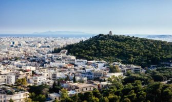 Athens cityscape with white buildings and large, forested hill